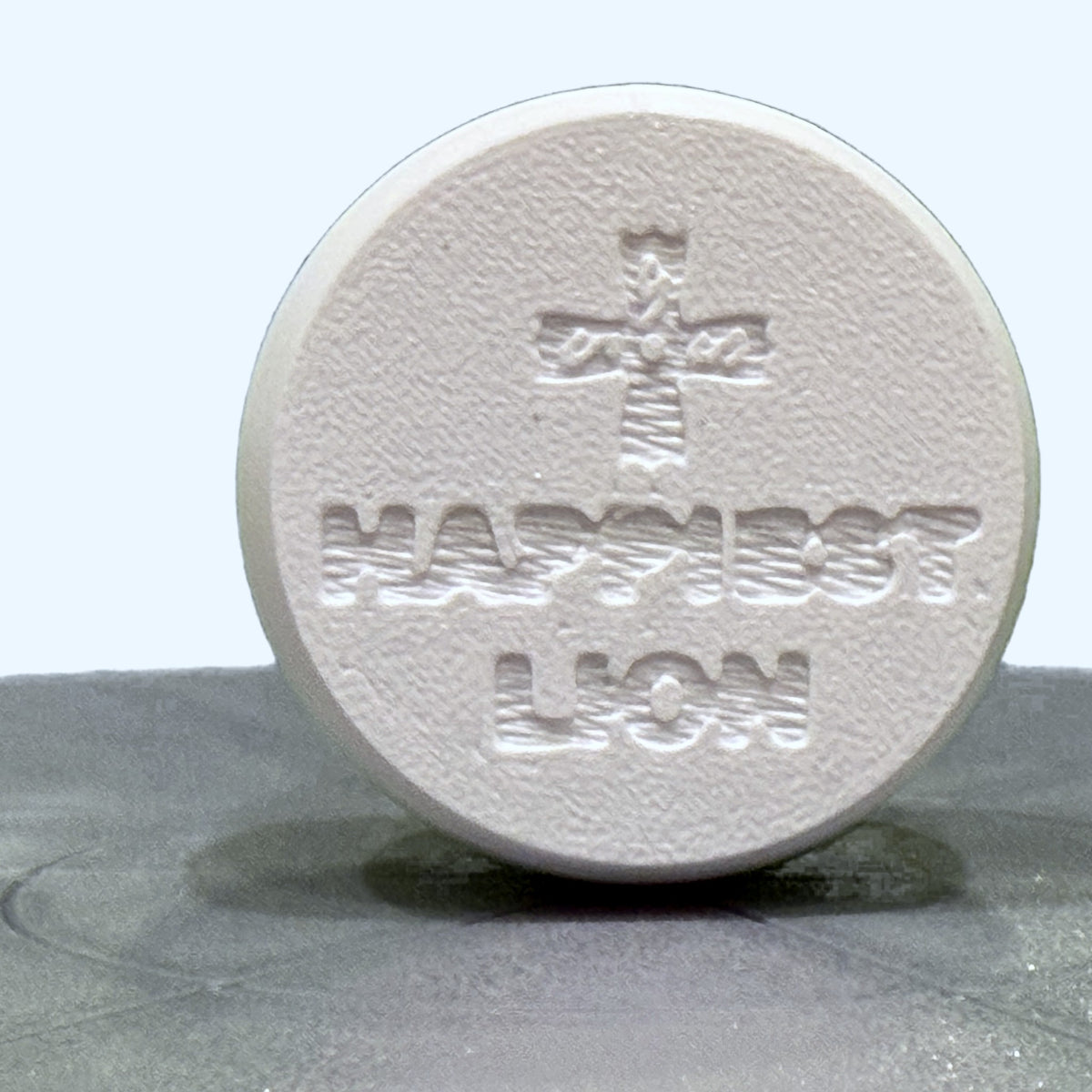 Orban Clicker keychain, underside: Coptic cross above the HAPPIEST LION makers mark