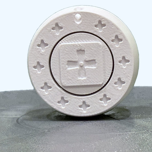 Orban Clicker keychain, top face: a Coptic cross on the pressed cap, ringed by eleven small crosses